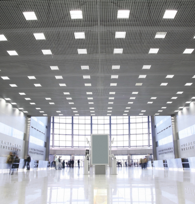 Image inside a very large space with a multi-use atmosphere, featuring people in transit and movement.